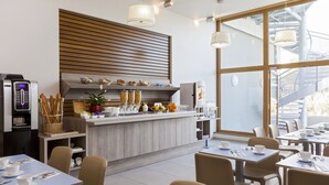 Un café moderne avec un comptoir, un espace salon et une vue sur un escalier.
