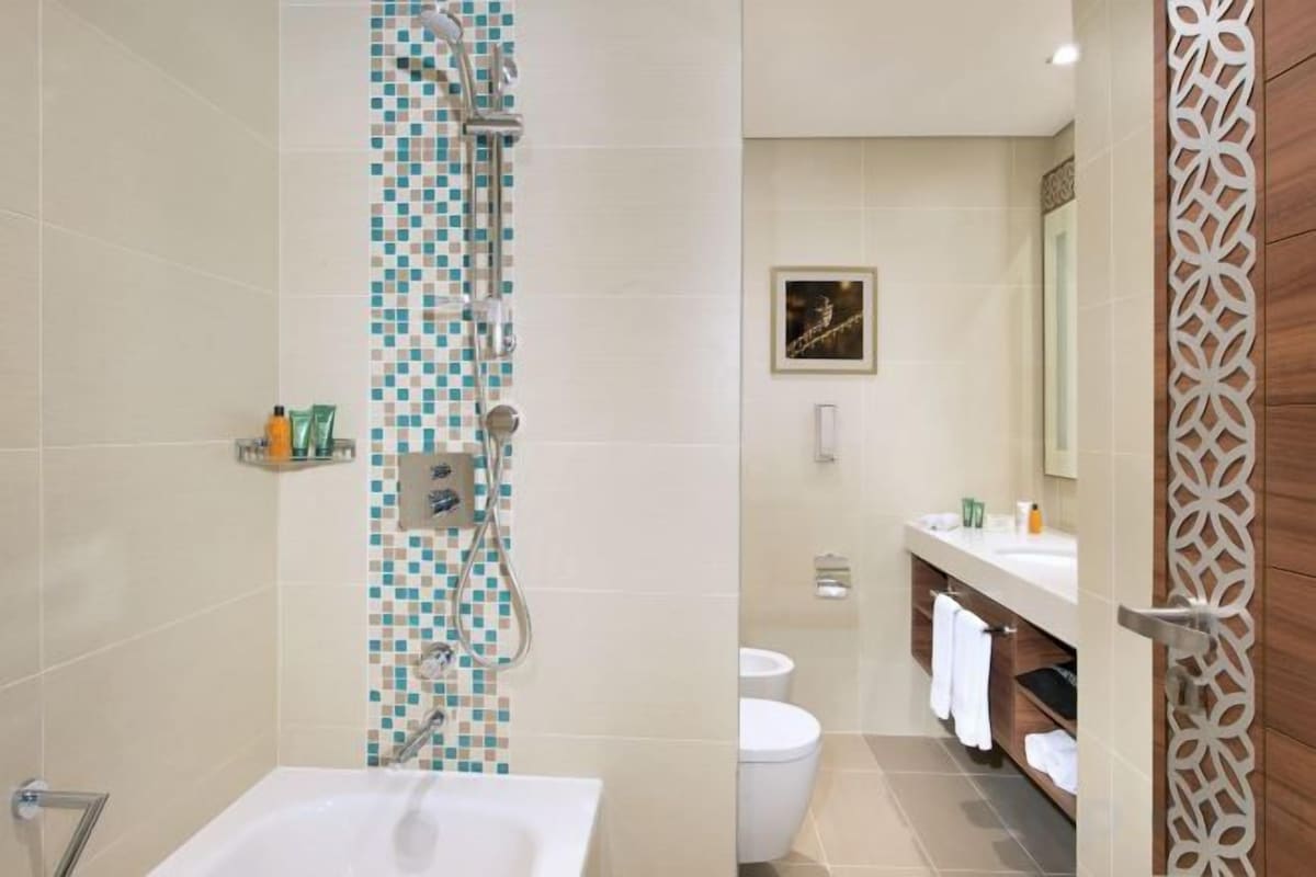 Une salle de bain avec douche, toilettes et baignoire.