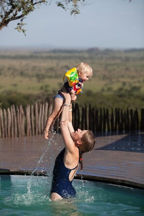 Una piscina al aire libre, sombrillas, tumbonas