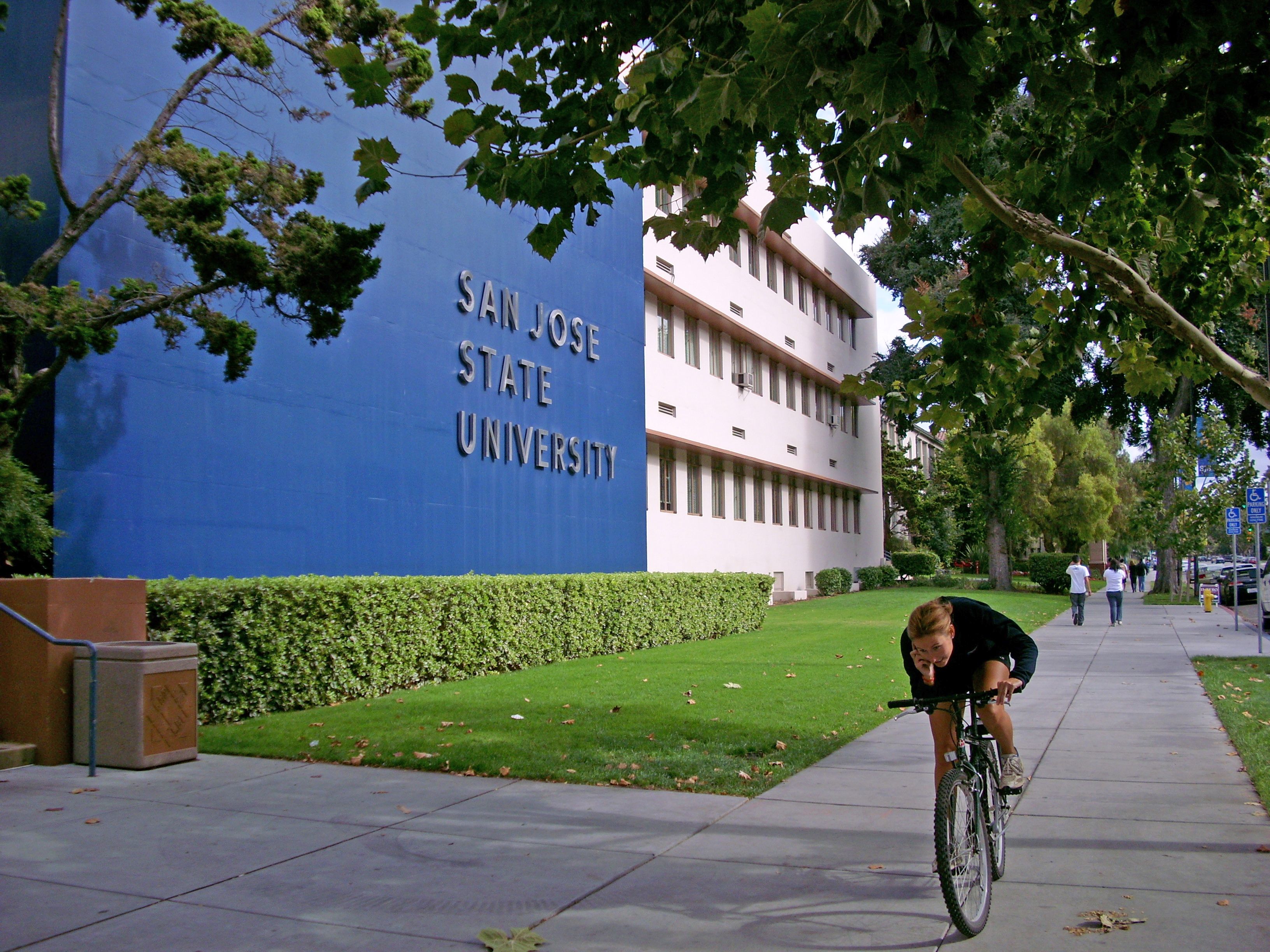 A building with a blue wall and the text "SAN JOSE STATE UNIVERSITY" on it.