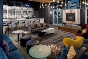 A modern lounge area with a bar, seating arrangements, and a fireplace. - Aloft by Marriott Santa Clara (San Jose)
