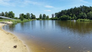 A calm river with a sandy bank, a solar panel structure, and a bird near the water's edge. - Pension Haus Heitzig (Lippstadt)