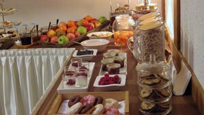 A breakfast buffet with various fruits, pastries, and beverages. - Pension Haus Heitzig (Lippstadt)
