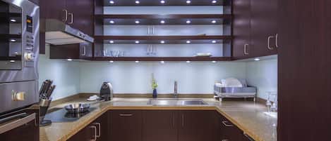Una cocina moderna con armarios de madera oscura, electrodomésticos de acero inoxidable y encimera de granito.