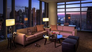 Ein modernes Wohnzimmer mit Blick auf die Stadt, ausgestattet mit einem Sofa, einem Couchtisch und zwei Lampen.