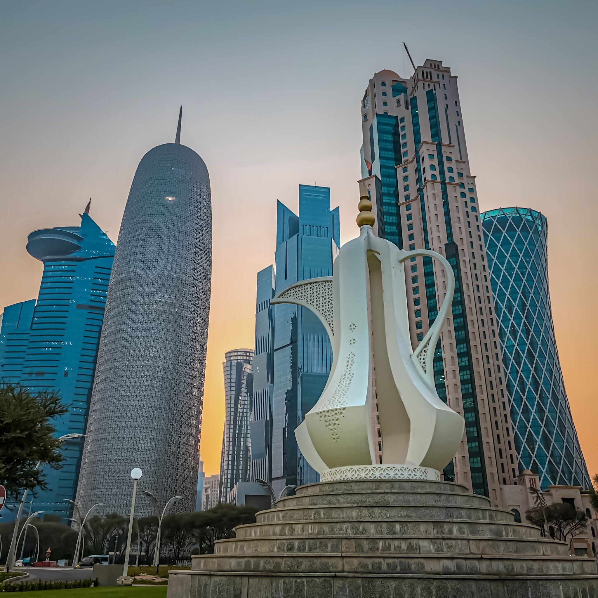 A modern cityscape with tall buildings and a unique sculpture in the foreground.