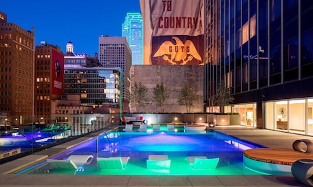 Una piscina al aire libre, sillones reclinables de piscina