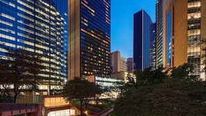 A modern urban area with high-rise buildings, a pedestrian bridge, and a well-lit plaza. - Hilton Garden Inn Downtown Dallas (Dallas)