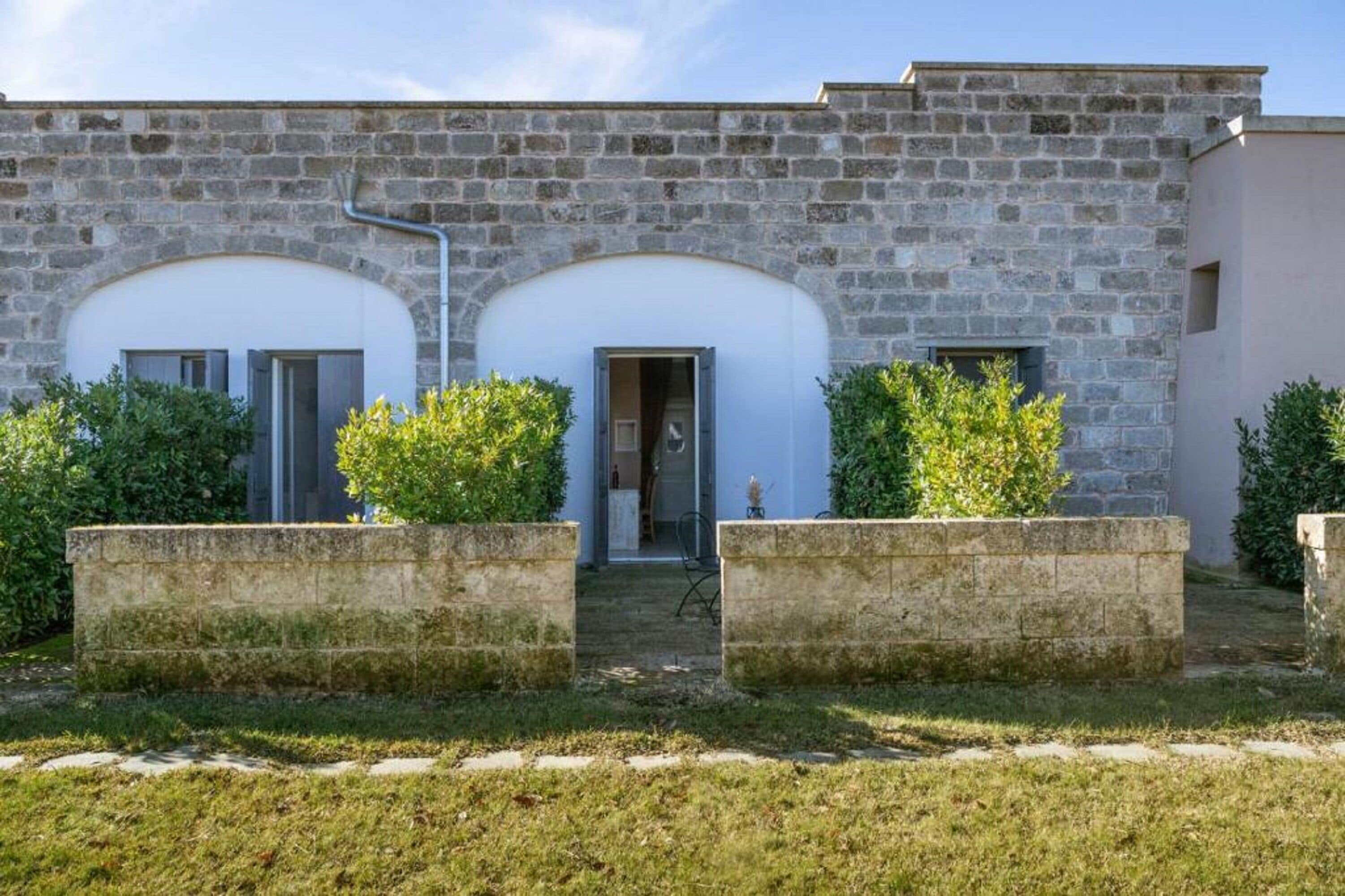 Un bâtiment en pierre doté de deux portes cintrées et d’une petite entrée.