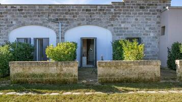 Un bâtiment en pierre doté de deux portes cintrées et d’une petite entrée.