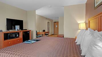 Una habitación de hotel con cama, televisión, escritorio y microondas.
