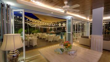An indoor area with a pool, outdoor seating, and a ceiling fan.