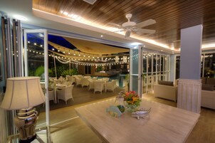 An indoor area with a pool, outdoor seating, and a ceiling fan.