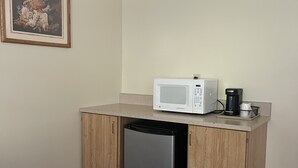 Ett litet, praktiskt kök med mikrovågsugn, kaffebryggare och diskmaskin.