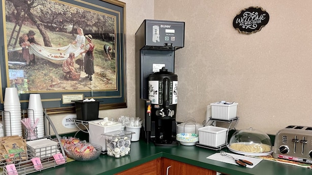 Ett köksutrymme med en kaffemaskin, en brödrost och diverse köksredskap.