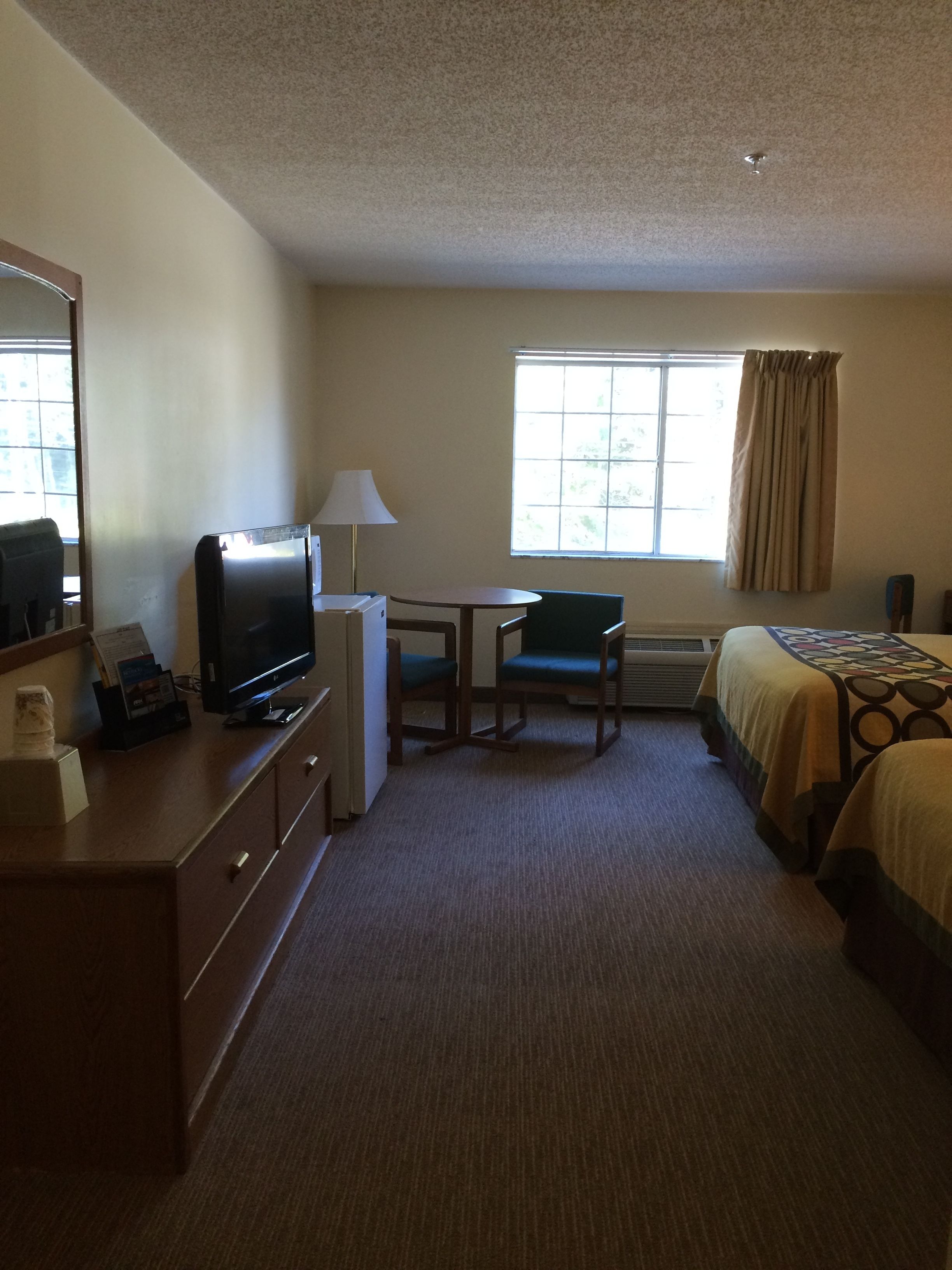 Une chambre d’hôtel équipée d’un bureau, d’une chaise, d’une télévision et d’un lit.