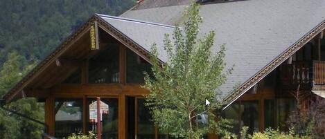 A wooden lodge with a steep roof, large windows, and a sign reading "Concorde".
