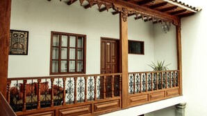 A balcony with a wooden railing and a potted plant. - Illa Hotel (Cusco)