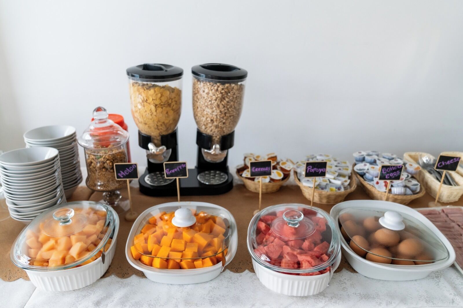 A buffet with various food items including fruits, cereals, and eggs.
