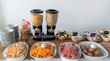 A buffet with various food items including fruits, cereals, and eggs.