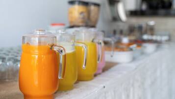 A breakfast buffet with various beverages in clear glass containers.
