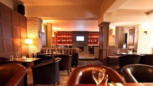 A restaurant with leather seating, a fireplace, and a television in the background. - Harty Costello Townhouse (Ballybunion)
