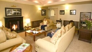 A cozy living room with a fireplace, a sofa, a coffee table, and a bookshelf. - Harty Costello Townhouse (Ballybunion)