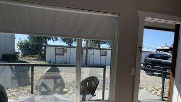 A room with a large window overlooking a parking area and a building.