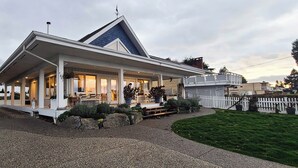A modern house with a covered porch, a well-maintained lawn, and a white picket fence.