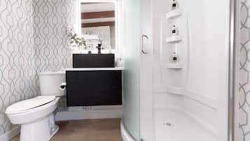 A modern bathroom with a toilet, sink, and shower.