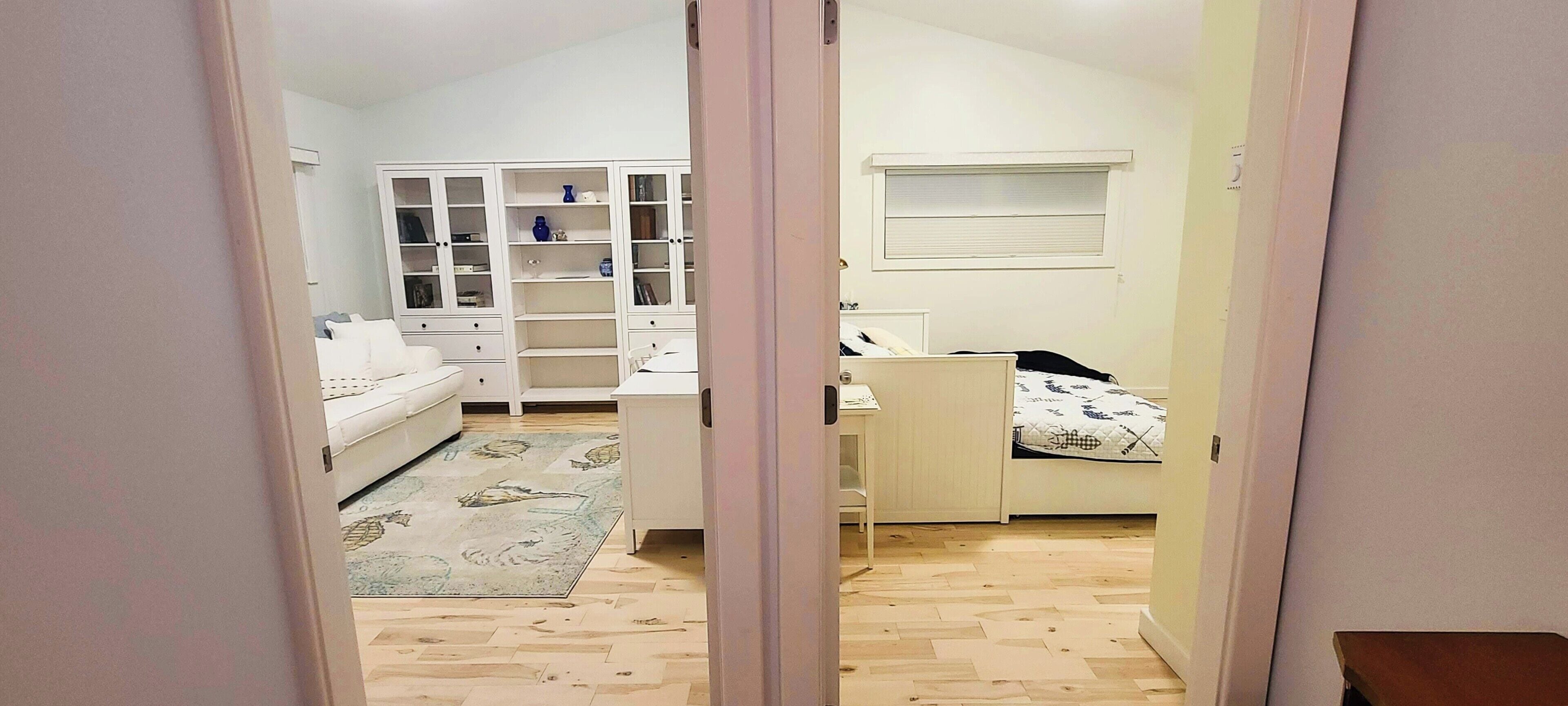 Un dormitorio con cama, escritorio, silla, armario y ventana.