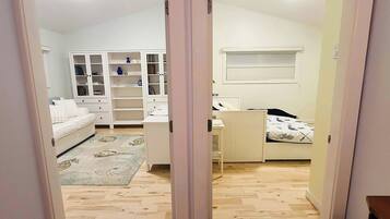 Un dormitorio con cama, escritorio, silla, armario y ventana.