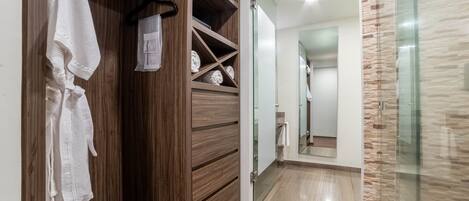 Un baño moderno con tocador de madera, cabina de ducha de vidrio y espejo.