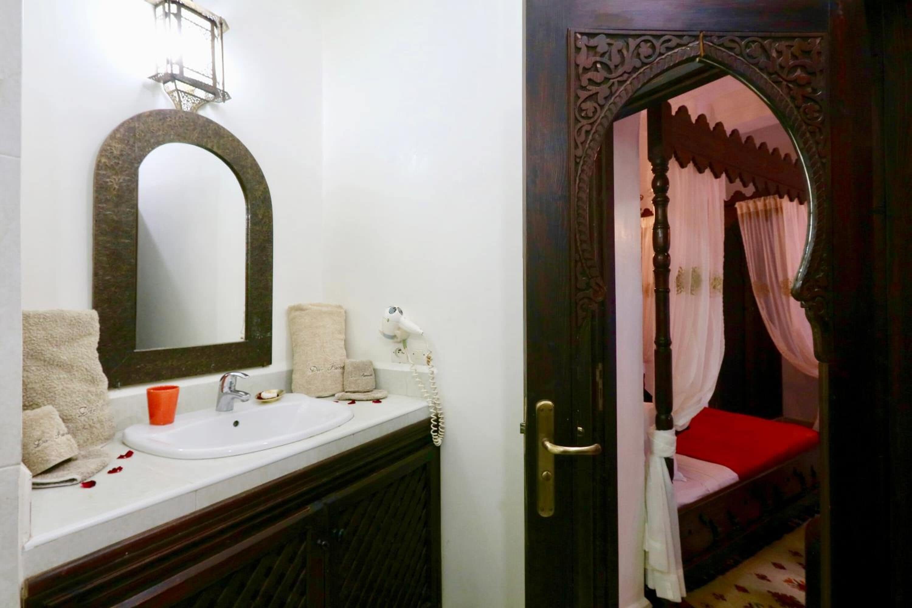Une salle de bain avec un grand miroir, un lavabo et un meuble-lavabo.