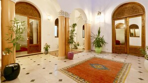 A spacious lobby with high ceilings, ornate arches, and a patterned carpet. - Dar Pamella (Marrakech)