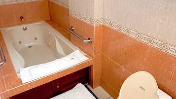 Een badkamer met een bad, toilet en een handdoekhouder.