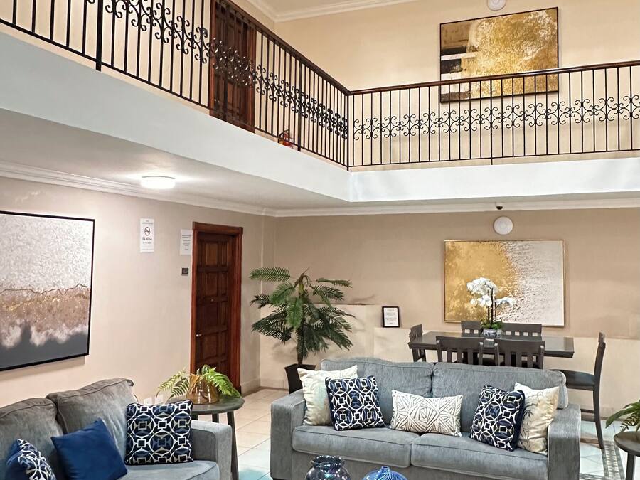A multi-level living area with two grey sofas, a coffee table, and a dining table.