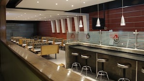 A modern restaurant with a bar area, seating, and a counter with stools. - Hotel Andros (Colon)