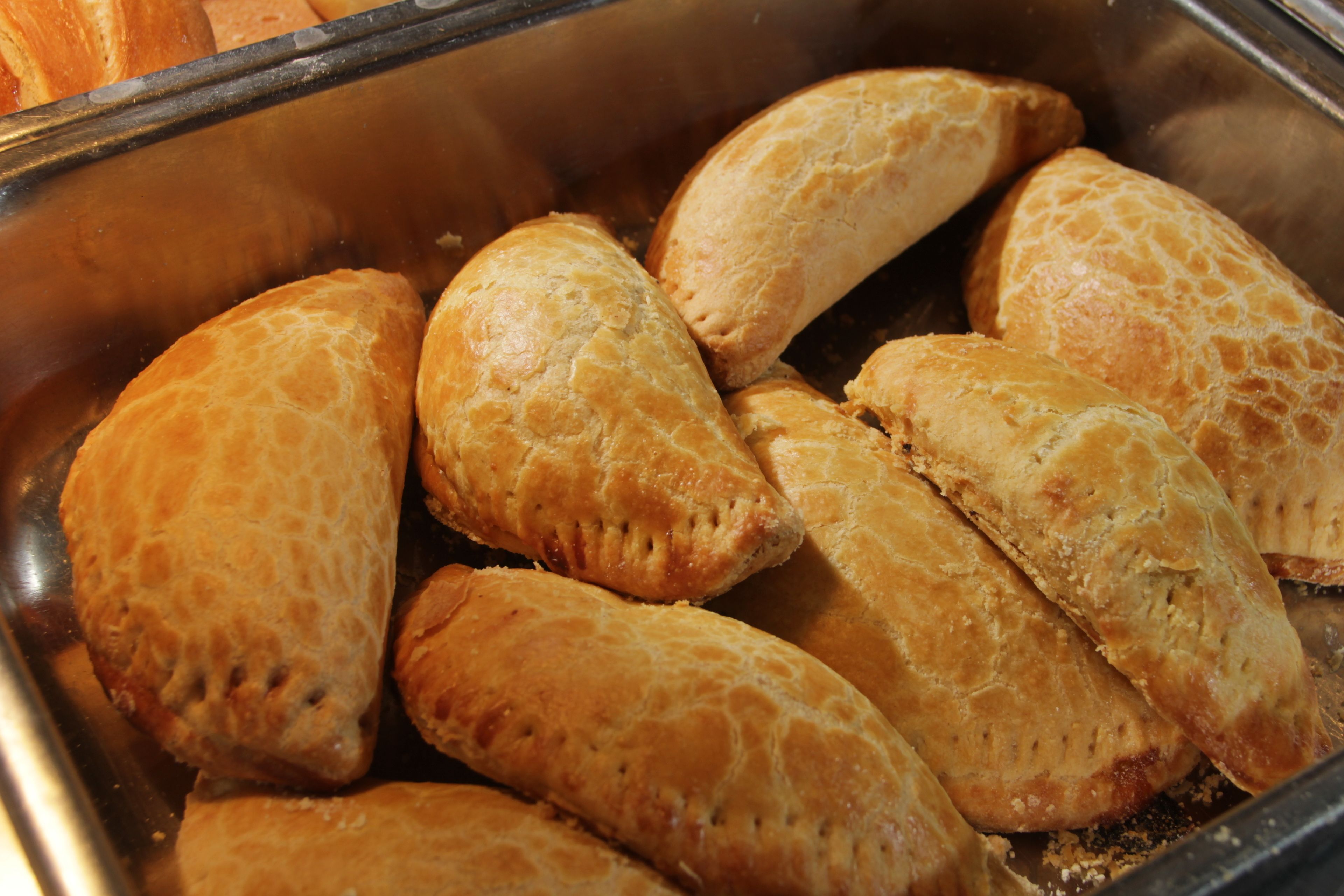 A stainless steel sink with several golden-brown pastries.