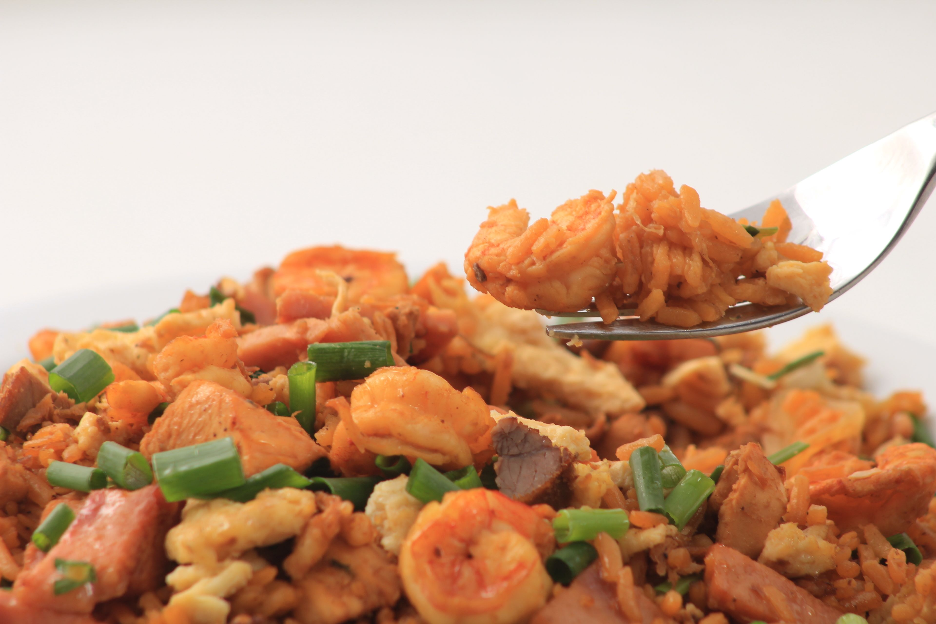 A close-up of a dish with rice, shrimp, and vegetables.