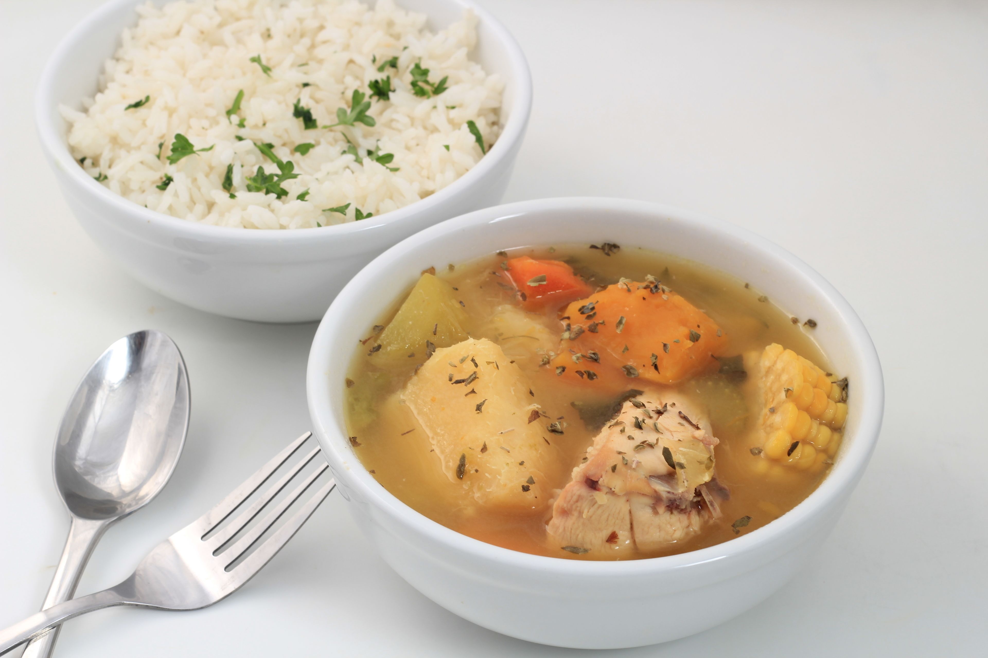Deux bols de nourriture : l’un contient du riz et l’autre, une soupe à base de légumes et de viande.