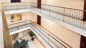 A multi-level interior with balconies, a dining area, and artwork. - Hotel Andros (Colon)
