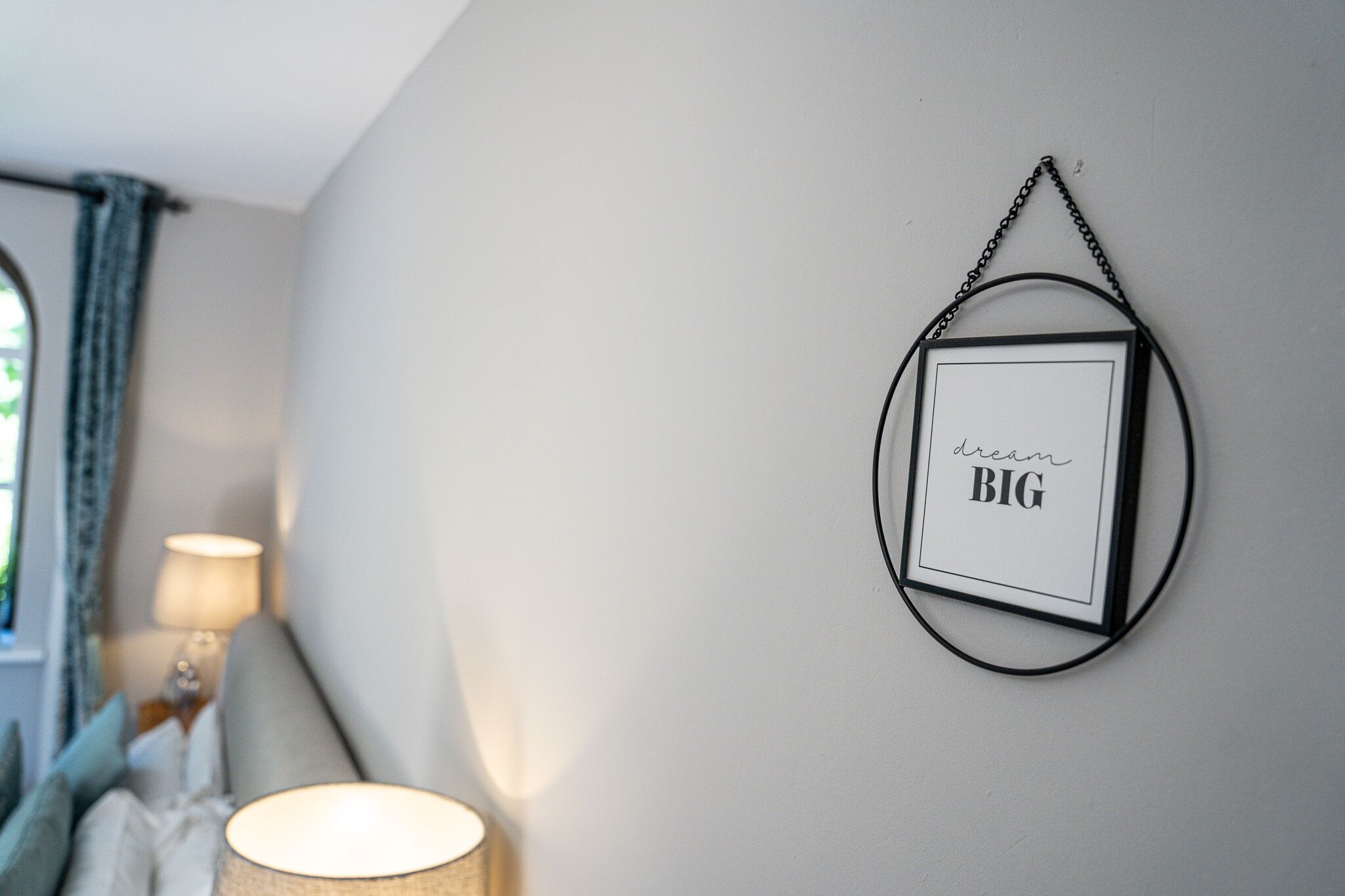 A framed picture with the text "dream BIG" on a wall.