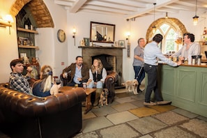 A cozy pub with a fireplace, leather seating, and a bar area. - Castle at Edgehill (Banbury)