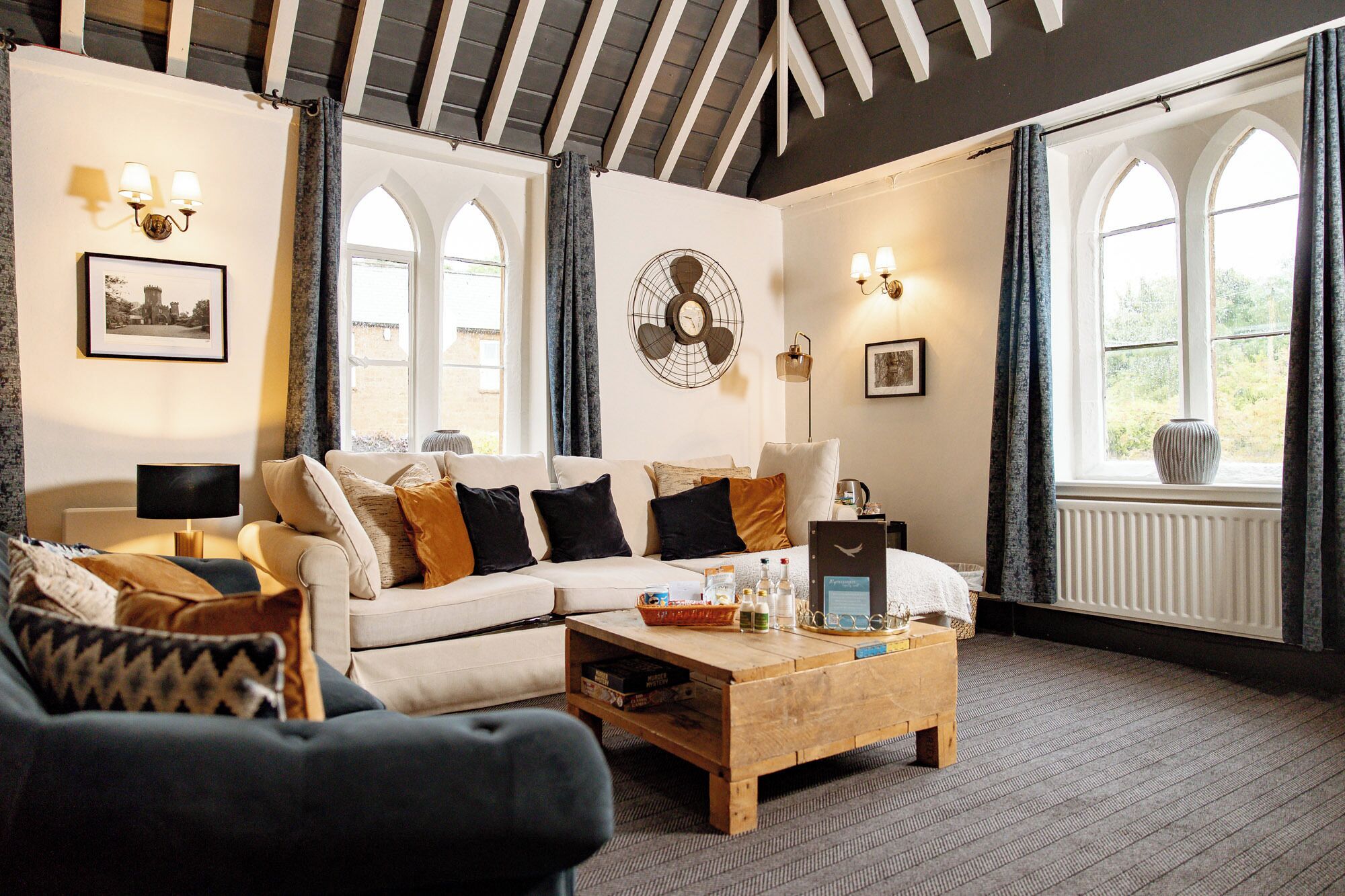 A cozy living room with a sofa, coffee table, and large windows.