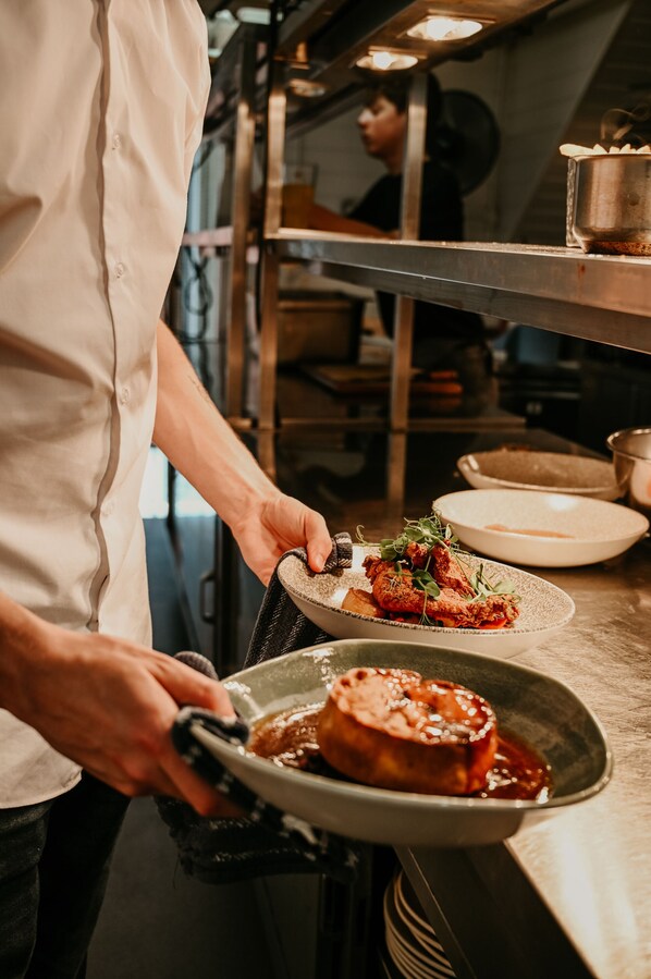 A chef serving food in a professional kitchen. - The Dragon (Derby)