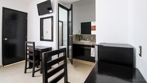 A modern kitchen with a black countertop, a sink, and a mirror above it. - Gayser Apartamentos (Valladolid)