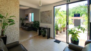 A lobby with a map, seating area, and potted plants. - Gayser Apartamentos (Valladolid)