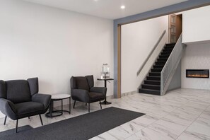 Una sala de estar moderna con un sofá, sillones, una mesita y una chimenea.