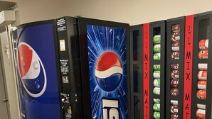 Un espace comprenant un distributeur automatique orné du logo Pepsi, un appareil pour préparer des boissons mélangées et une étiquette JOLIN.